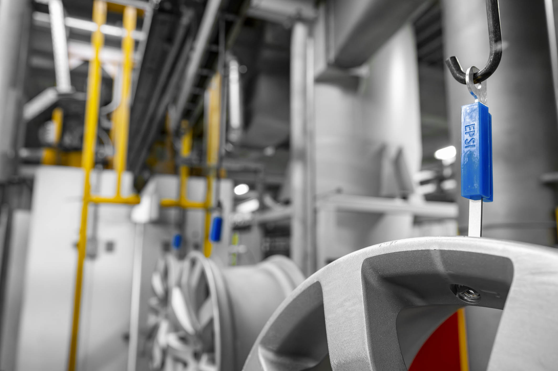 Close-up of EPSI Hanging Adapter supporting an automotive wheel on a finishing line