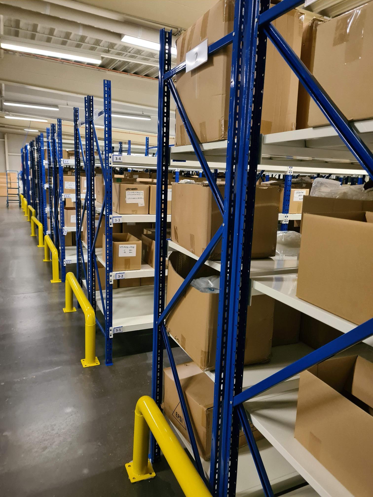EPSI industrial metal storage racks with blue uprights and gray shelves holding warehouse inventory and supplies