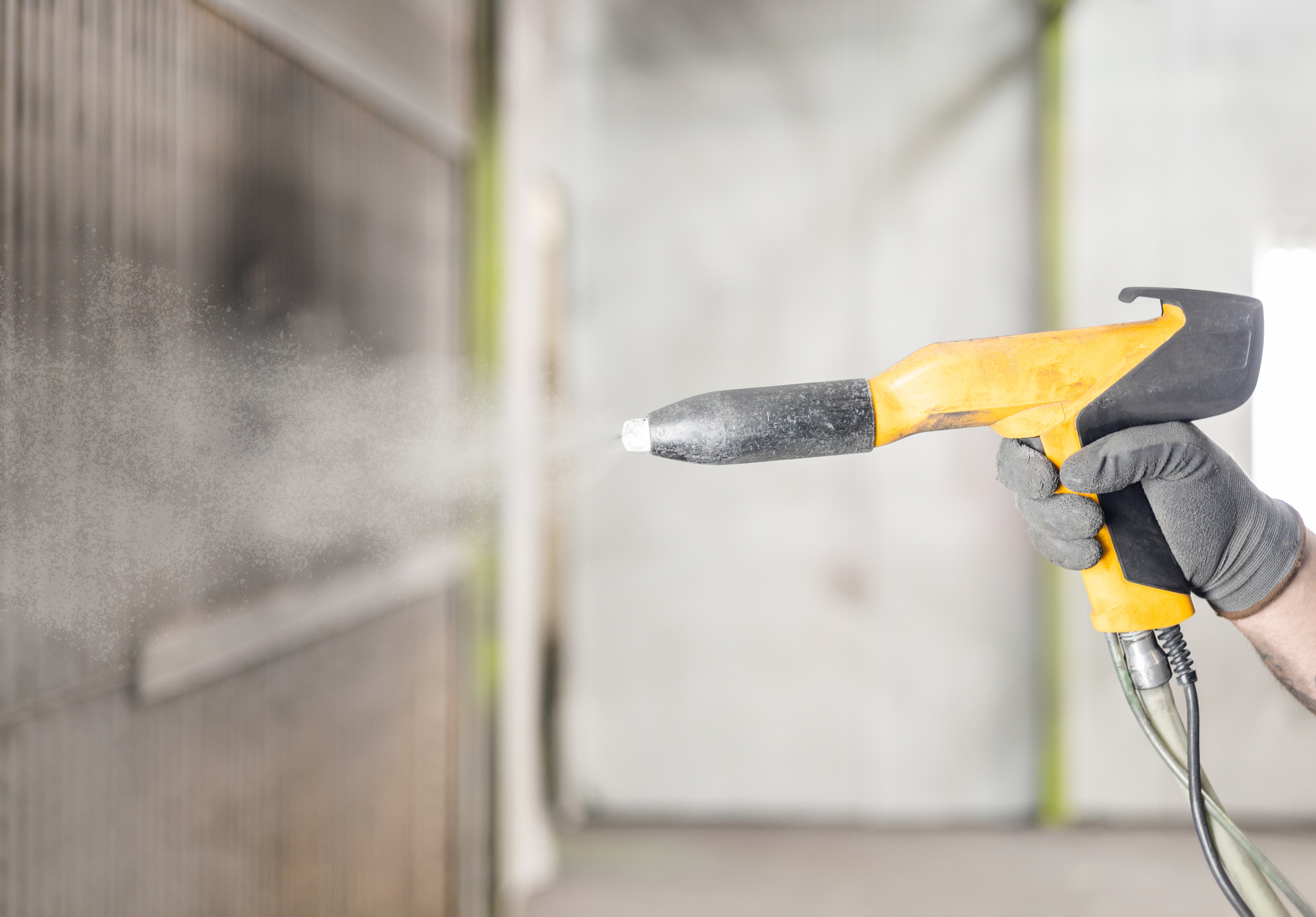 Powder coating being applied to industrial metal components