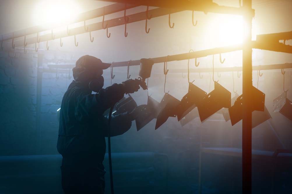 Parts hanging from hooks during powder coating