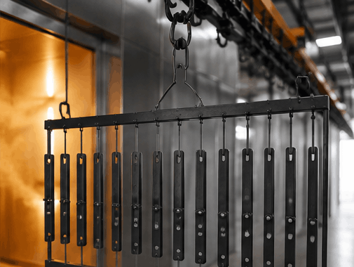 Custom powder coating rack with parts going into oven